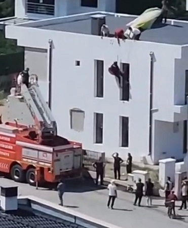 Kontrolünü kaybeden paraşütçü çatıda asılı kaldı